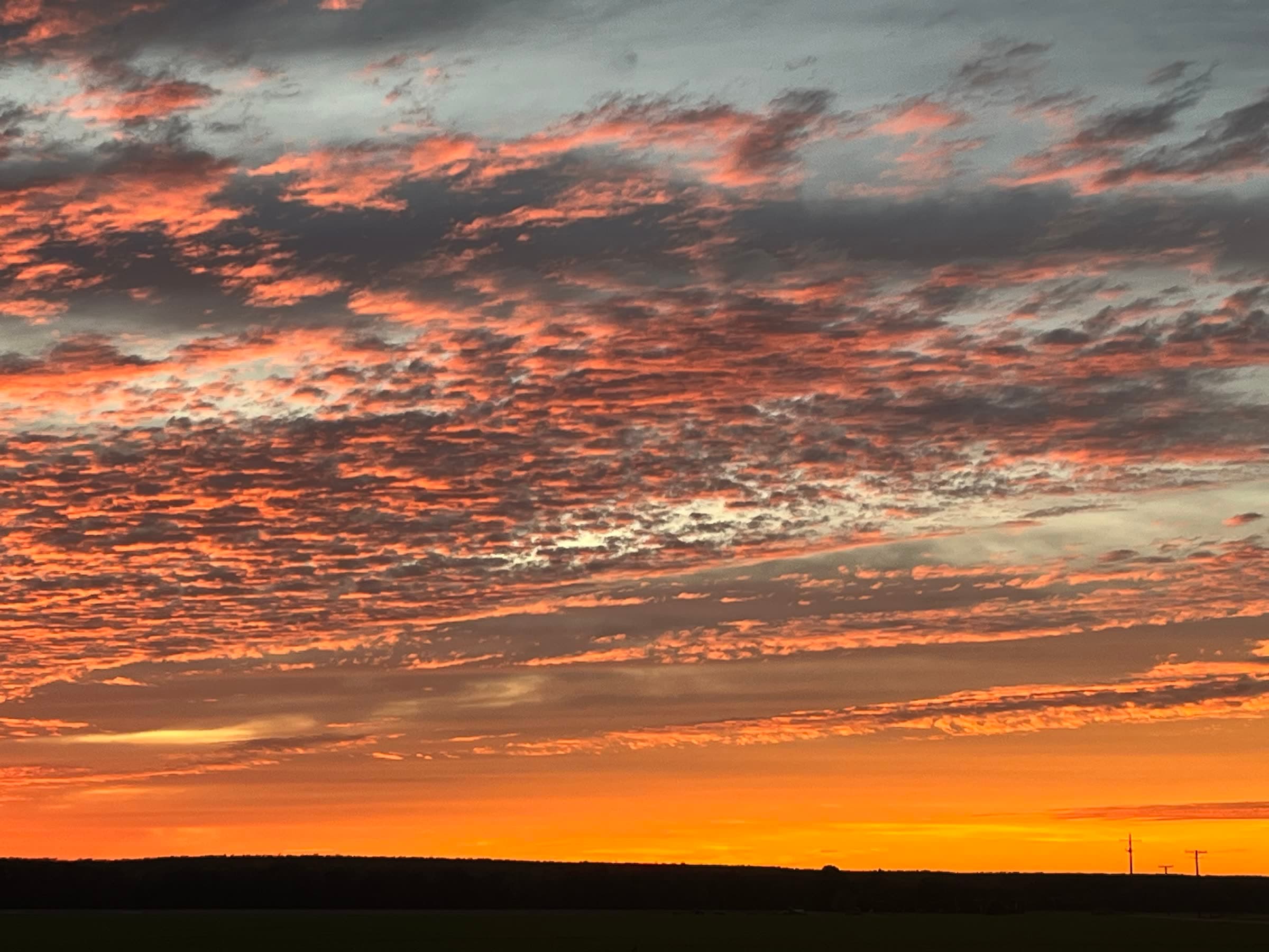 A vivid orange sunset over open Arkansas fields