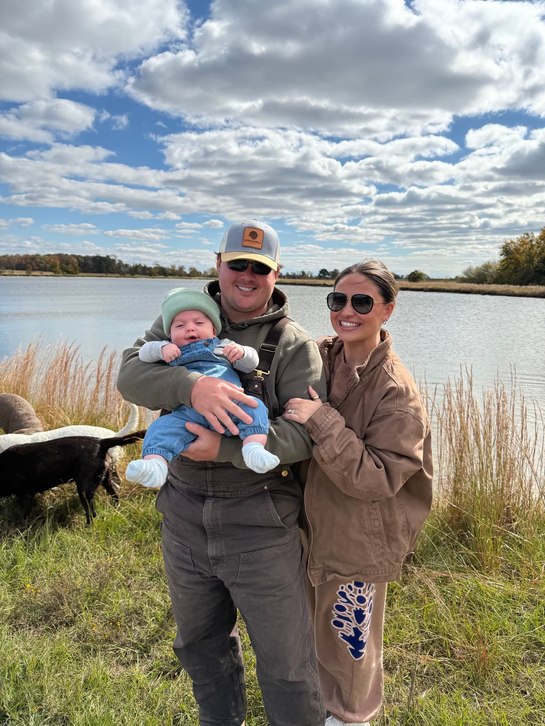 Witham family members holding a young child beside the water