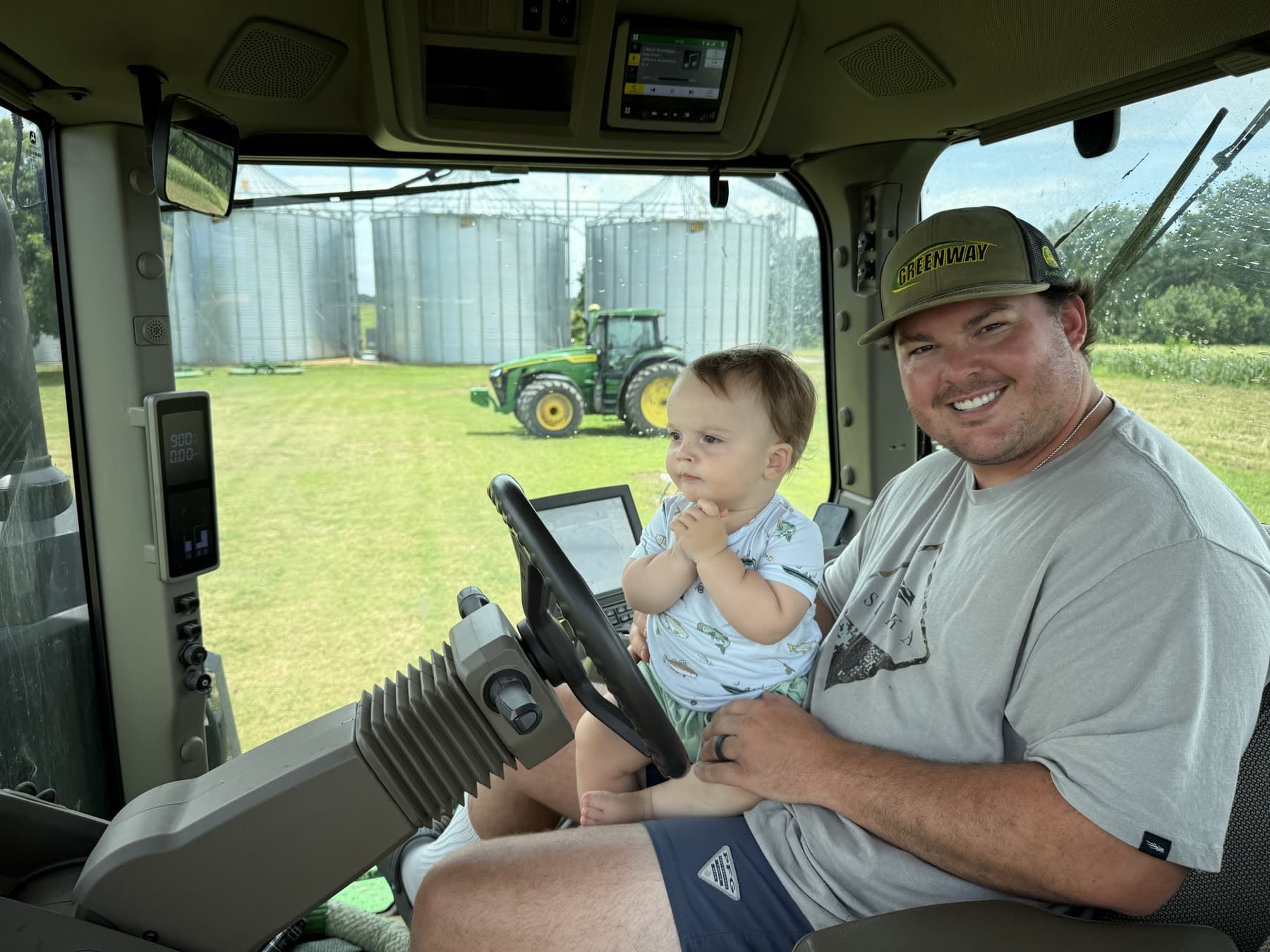 A Witham family member and young child inside a tractor cab